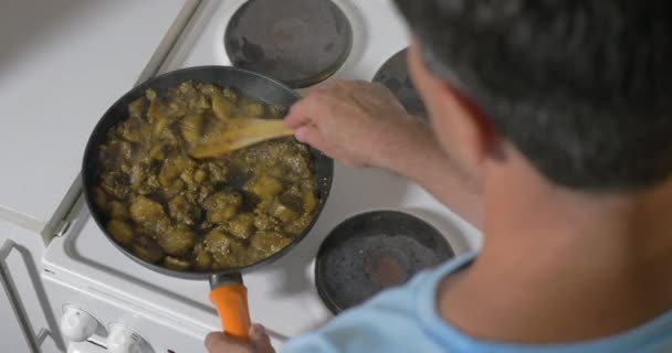 Hombre cocinando verduras guisadas en casa — Vídeo de stock