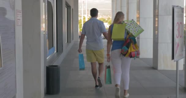 Jonge mensen verlaten handel centrum gelukkig met winkelen — Stockvideo