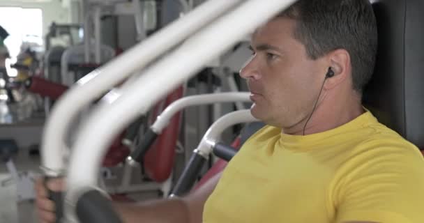 Man finishing set on chest press machine — Stock Video