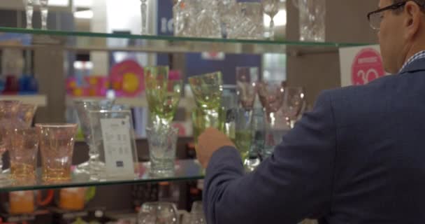 Человек делает снимок стекла в магазине — стоковое видео