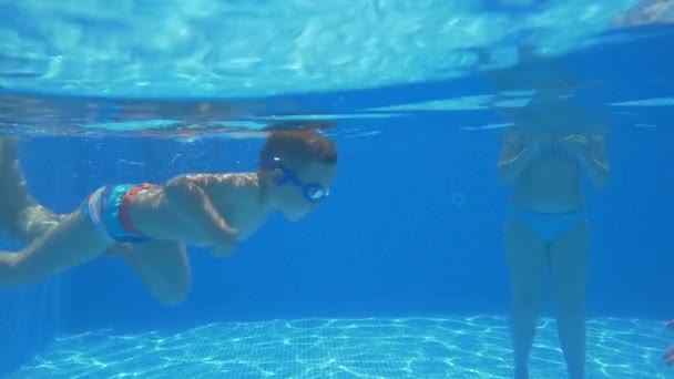Menino aprendendo a nadar na piscina com seus pais e avó — Vídeo de Stock