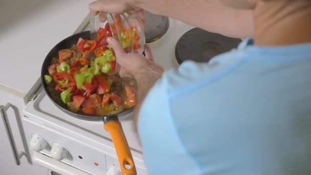 Az ember hozzá friss paprika bekerüljön a serpenyő — Stock videók