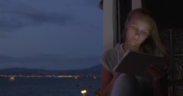 Woman with pad on hotel balcony at night — Stock Video