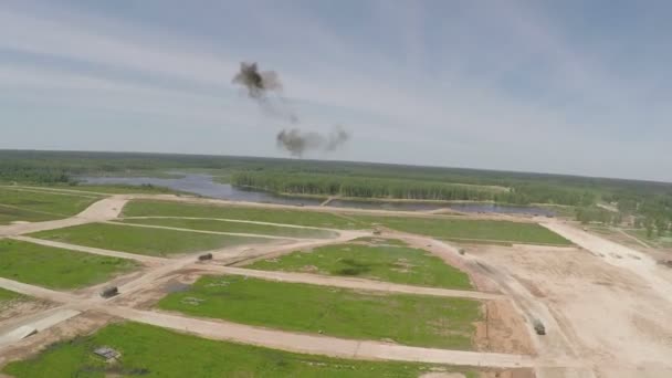 Vliegen over de militaire vrachtwagens die op het trainingsgebied rijden — Stockvideo