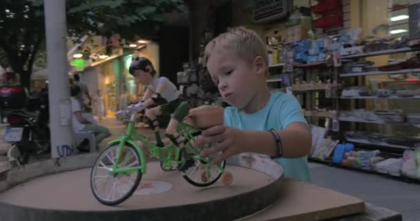 Niño jugando con juguete ciclista en la calle — Vídeos de Stock