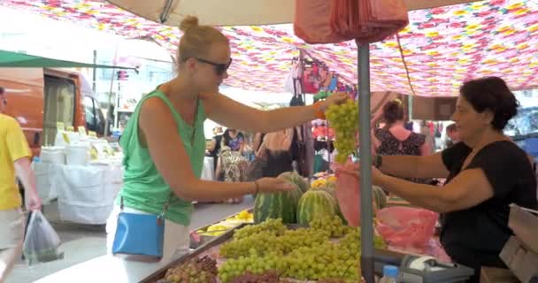 Junge Frau wählt Trauben vor dem Kauf — Stockvideo