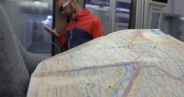 Mujer con mapa subterráneo en el tren — Vídeo de stock