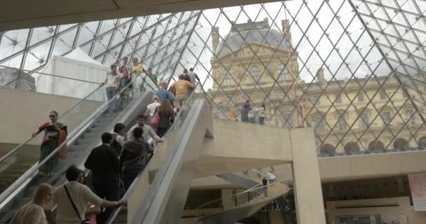 Mensen rijden roltrappen ondergrondse de Pyramide van het Louvre — Stockvideo