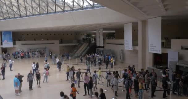 Bezoekers in de ondergrondse hal van de piramide van de Louvre — Stockvideo