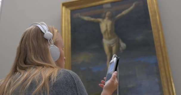 Mujer escuchando audioguía en la galería de arte — Vídeos de Stock