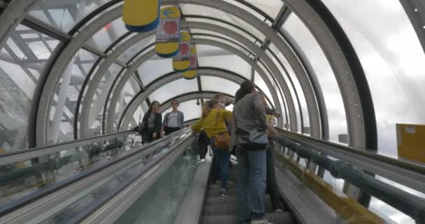People riding escalators in glass tube — Stock Video