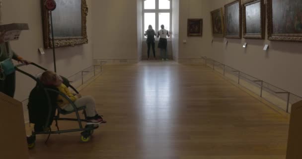 Женщина и ребенок прогуливаются по залам музея Лувра — стоковое видео