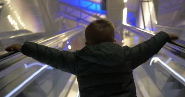 Child getting upstairs on escalator — Stock Video