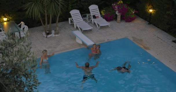 Família passa tempo na piscina exterior — Vídeo de Stock