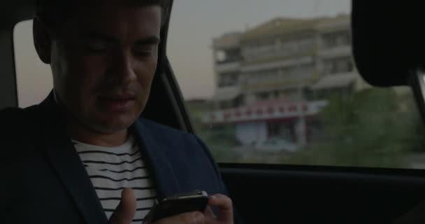 Человек, использующий смартфон в машине — стоковое видео