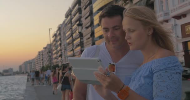 Couple regardant tablette à la plage — Video