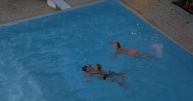 Baba, anne ve çocuk havuzda yüzme