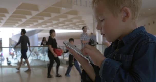 Criança olhando através das fotos no telefone inteligente — Vídeo de Stock