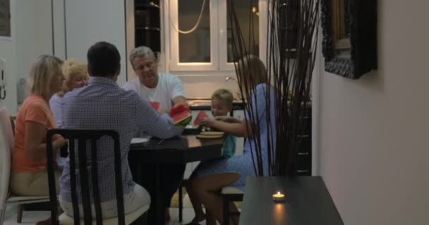 Familie watermeloen te eten in de dining room — Stockvideo