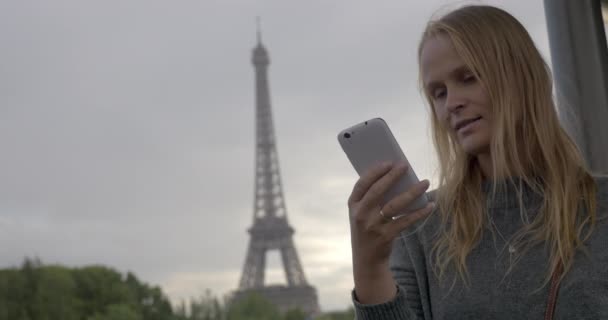 Mulher usando celular e tirando fotos da Torre Eiffel — Vídeo de Stock