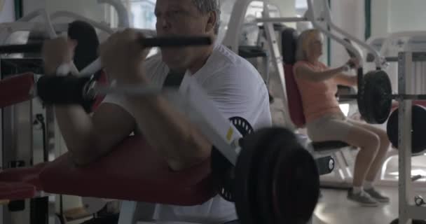 Hombre haciendo ejercicio en bíceps en el gimnasio — Vídeo de stock