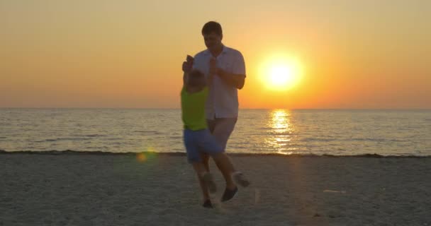 Pareja mayor abrazándose junto al mar al atardecer — Vídeo de stock