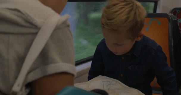 Jongen met moeder op zoek op de kaart in de trein — Stockvideo