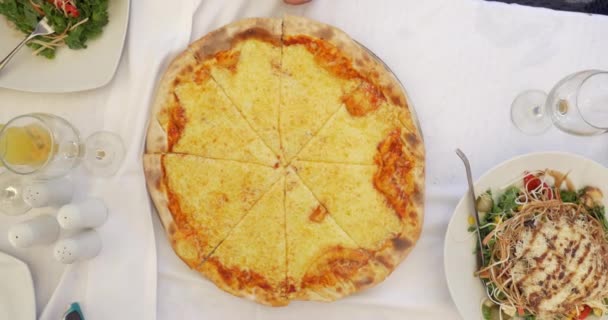 Gente tomando rebanadas de pizza de queso servida en la cafetería — Vídeos de Stock