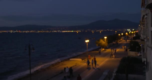 Vista nocturna de la playa y la ciudad desde la ventana del hotel con pareja — Vídeos de Stock