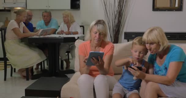 Abuelas y nietos con electrónica en casa — Vídeo de stock