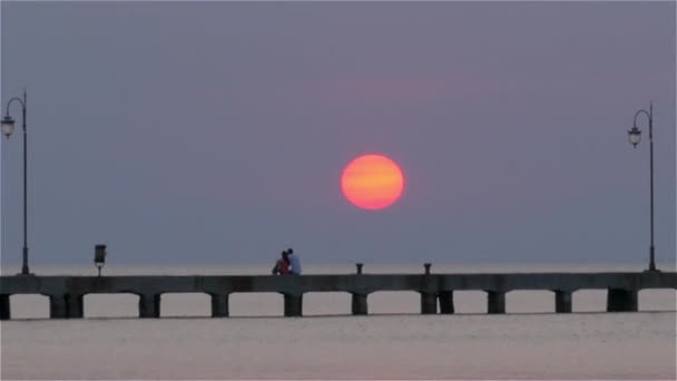 Gente en el muelle al atardecer — Vídeos de Stock