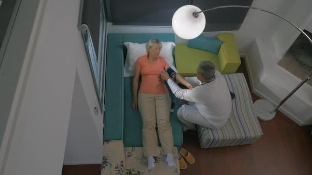 Dokter controle womans bloeddruk thuis — Stockvideo