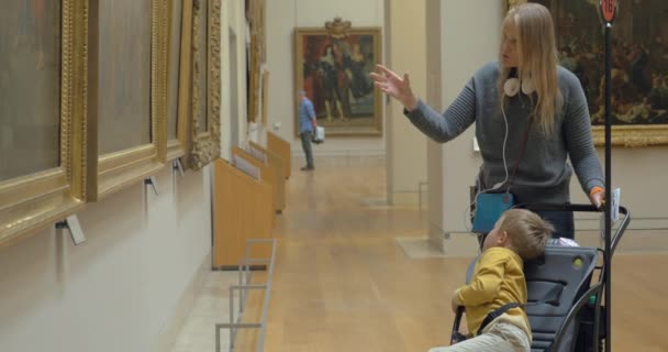 Μητέρα και παιδί βλέπουν πίνακες ζωγραφικής στο Μουσείο του Λούβρου — Αρχείο Βίντεο