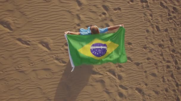 Γυναίκα με βραζιλιάνικη σημαία που κυματίζει στον αέρα, αεροφωτογραφία — Αρχείο Βίντεο