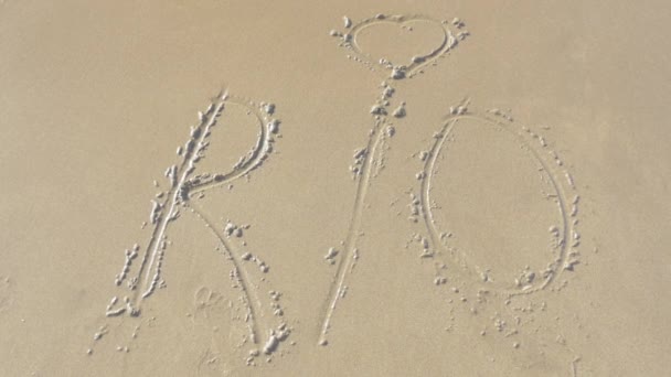 Mořská vlna mytí Rio text z písku — Stock video