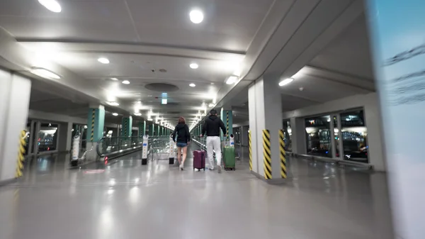 Travelers with baggage walking to flat escalator at Seoul airport — Stock Photo, Image