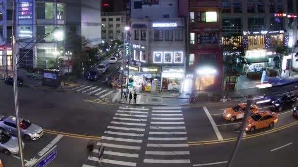 SEOUL, Coréia do Sul - OUTUBRO 22, 2015: Time lapse shot of T junction with pedestrian crossing and shop front and billboards — Vídeo de Stock