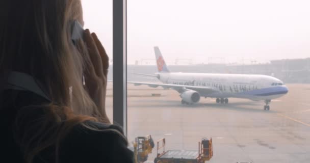Деловая женщина разговаривает по телефону перед вылетом — стоковое видео