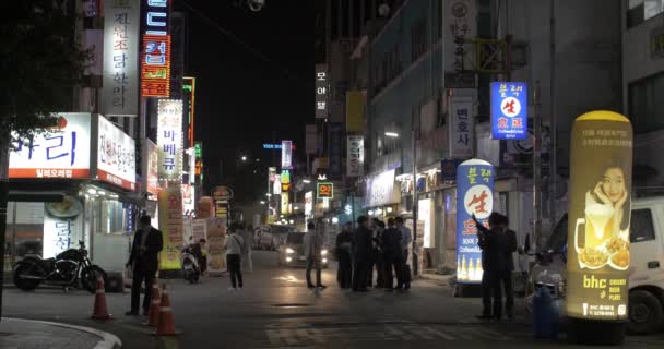 Calle nocturna con gente y muchas pancartas de la tienda. Seúl, Corea del Sur — Vídeo de stock