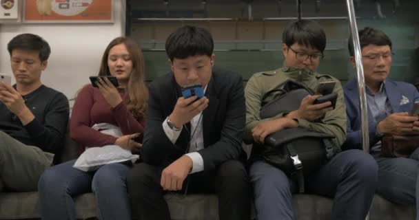 U-Bahn-Fahrgäste mit Handys. seoul, Südkorea — Stockvideo