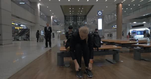 Donna sdraiata sulla panchina dell'aeroporto di Seoul, Corea del Sud — Video Stock