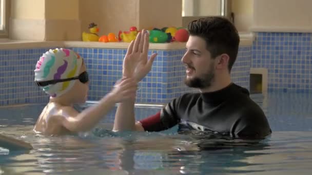 Rehabilitationszentrum Evexia, Schwimmunterricht, kleiner Junge und Lehrer im Schwimmbad — Stockvideo