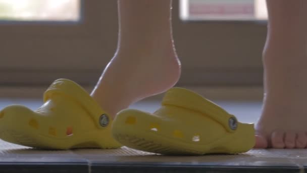 Enfant portant des chaussures en caoutchouc après avoir nagé dans la piscine — Video