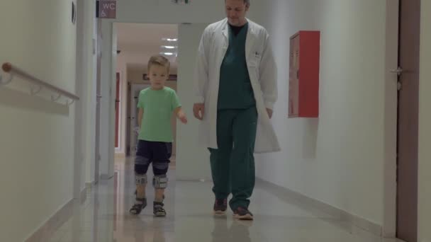 Médico y niño caminando en el pasillo del hospital — Vídeos de Stock