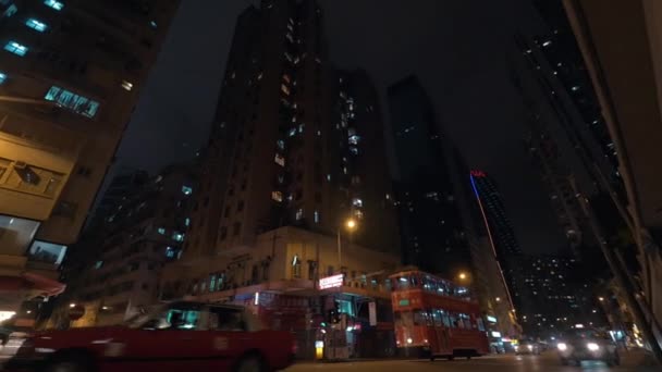 Noc miasto i wieżowce z ruchliwej drodze z przekazaniem dwupiętrowe autobusy i samochody — Wideo stockowe