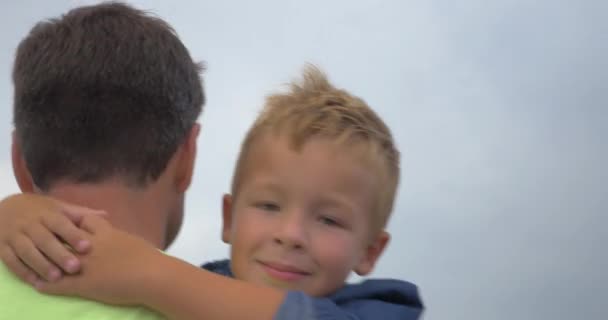 Vader loopt en houdt in armen zijn kleine zoon — Stockvideo