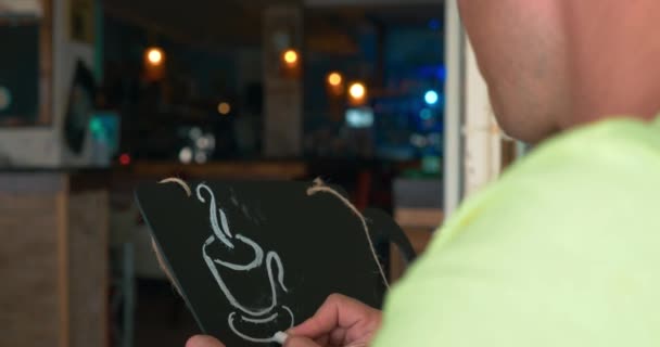 Человек рисует мелом на черной доске — стоковое видео