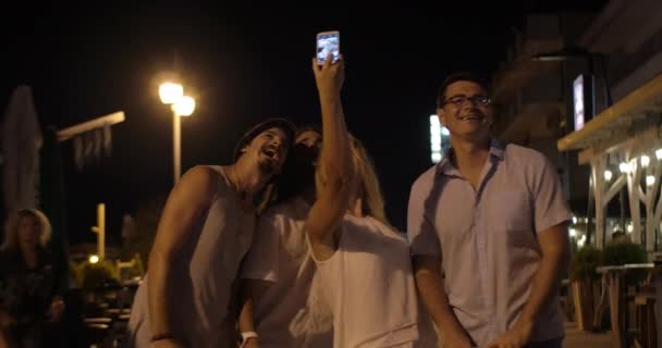 Dans la soirée dans la ville de Perea, Grèce jeune entreprise prenant selfies sur un téléphone portable — Video