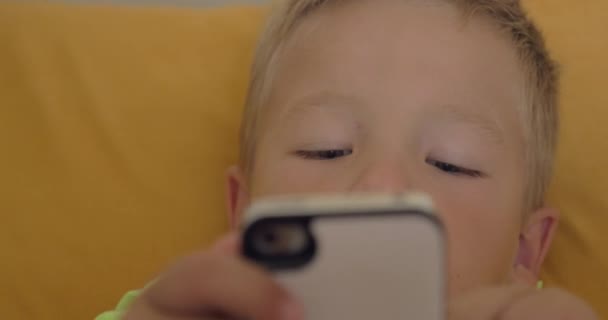 Gros plan du petit garçon jouant à un jeu sur le smartphone — Video