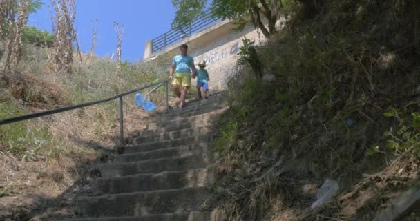 Na cidade Perea, Greece no parque abaixo das escadas pai com seu filho — Vídeo de Stock